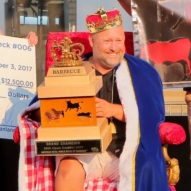 close up of blane hunter of porky butts bbq accepts check for american royal world series of bbq